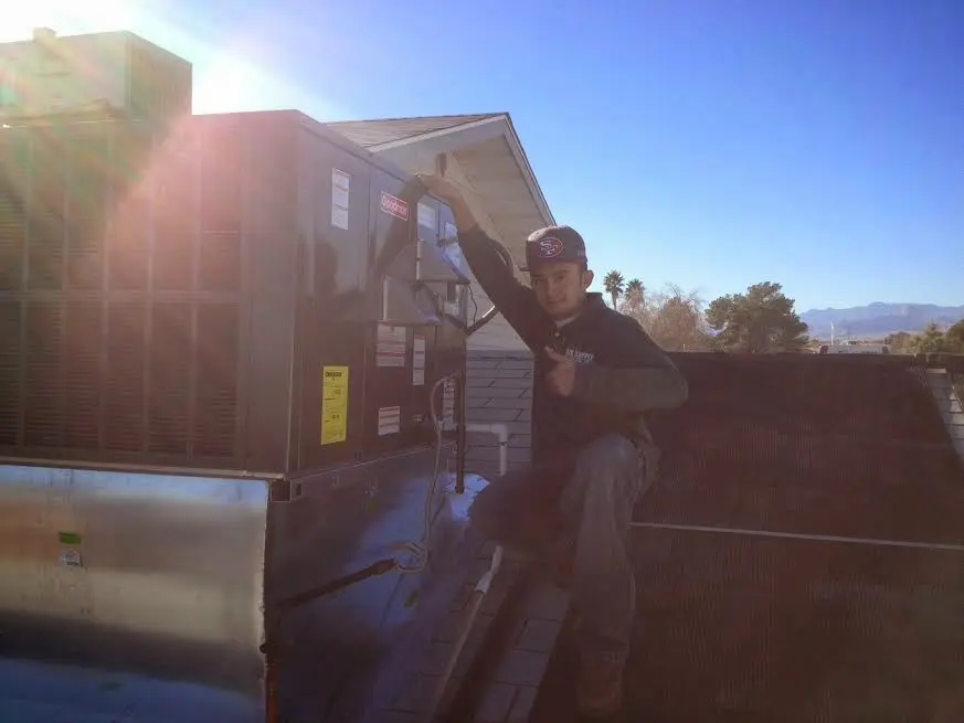 HVAC technician performing AC Tune-Up on a rooftop unit in Gulfport